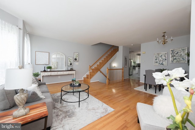 20976 Kittanning Ln, Ashburn, VA 20147 - living area with stairway, a chandelier, and light wood-style flooring