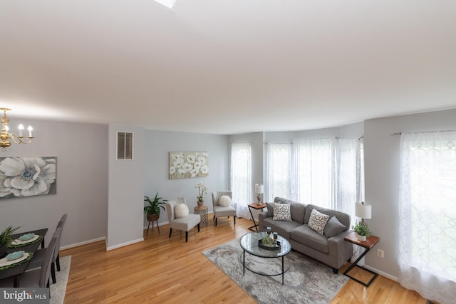 20976 Kittanning Ln, Ashburn, VA 20147 - living room with a chandelier, light wood-style floors, and baseboards