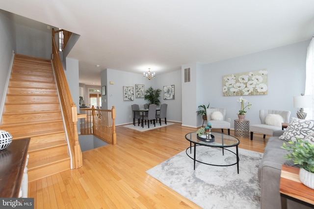 20976 Kittanning Ln, Ashburn, VA 20147 - living room with wood finished floors, a chandelier, and stairway