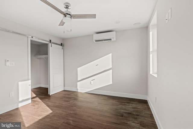 2453 Turner St, Philadelphia, PA 19121 - unfurnished bedroom with a wall mounted air conditioner, dark wood-style floors, a barn door, and baseboards