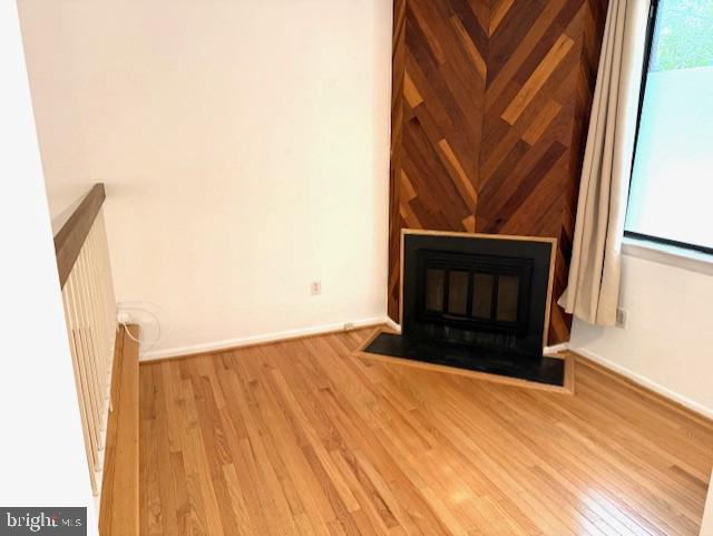 10627 Muirfield Dr, Potomac, MD 20854 - unfurnished living room with wood finished floors, a glass covered fireplace, and baseboards