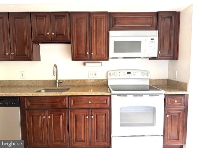 10627 Muirfield Dr, Potomac, MD 20854 - kitchen featuring white appliances, a sink, light stone counters, and dark brown cabinets