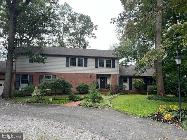232 N Shore Ct, Seaford, DE 19973 - view of front of house featuring brick siding, a front lawn, and a chimney