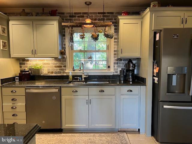 232 N Shore Ct, Seaford, DE 19973 - kitchen featuring appliances with stainless steel finishes, a sink, decorative backsplash, ornamental molding, and dark stone countertops