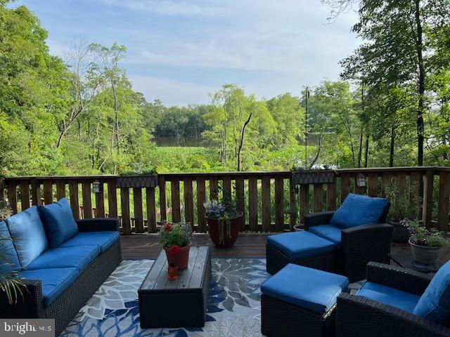 232 N Shore Ct, Seaford, DE 19973 - wooden deck with an outdoor hangout area and a forest view