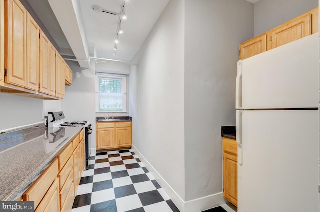 3024 Tilden St NW # 6, Washington, DC 20008 - kitchen with freestanding refrigerator, black stove, light brown cabinets, dark flooring, and rail lighting