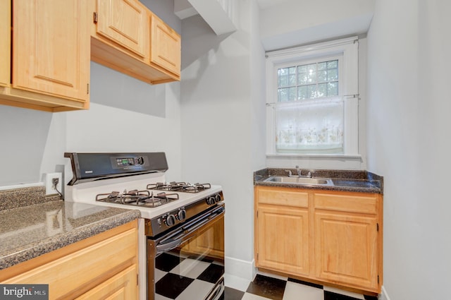 3024 Tilden St NW # 6, Washington, DC 20008 - kitchen with white range with gas cooktop, light brown cabinets, a sink, and tile patterned floors