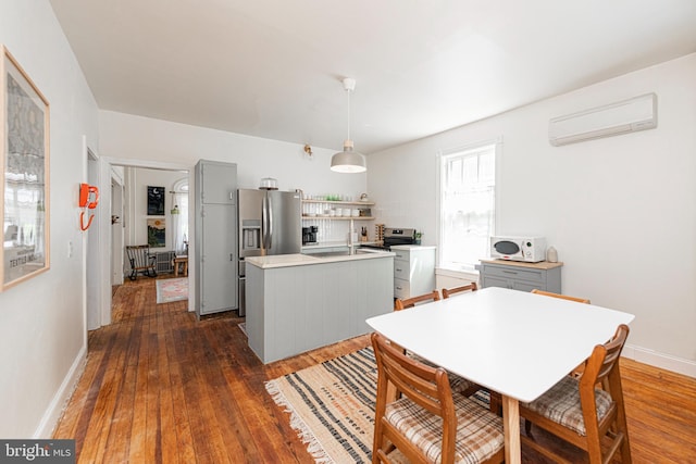 510 E Main St, Birdsboro, PA 19508 - kitchen with an AC wall unit, appliances with stainless steel finishes, dark wood-style flooring, light countertops, and a kitchen island