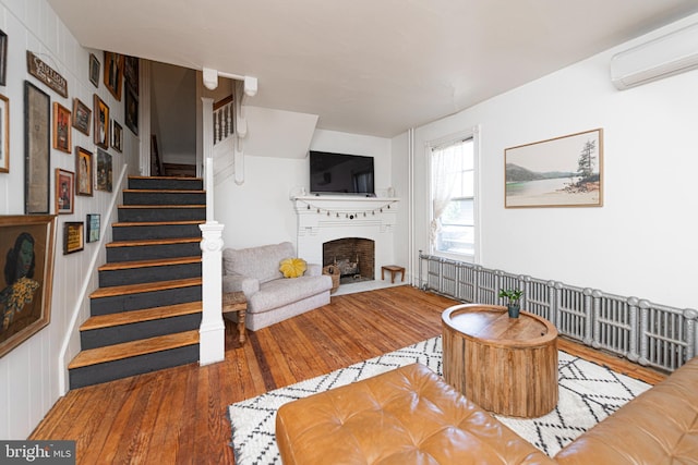 510 E Main St, Birdsboro, PA 19508 - living room featuring an AC wall unit, hardwood / wood-style floors, a fireplace, and stairs
