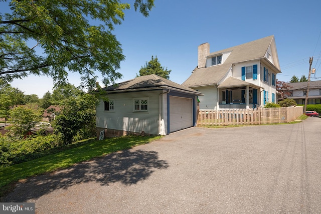 510 E Main St, Birdsboro, PA 19508 - view of front of house with a chimney, asphalt driveway, a garage, and an outbuilding
