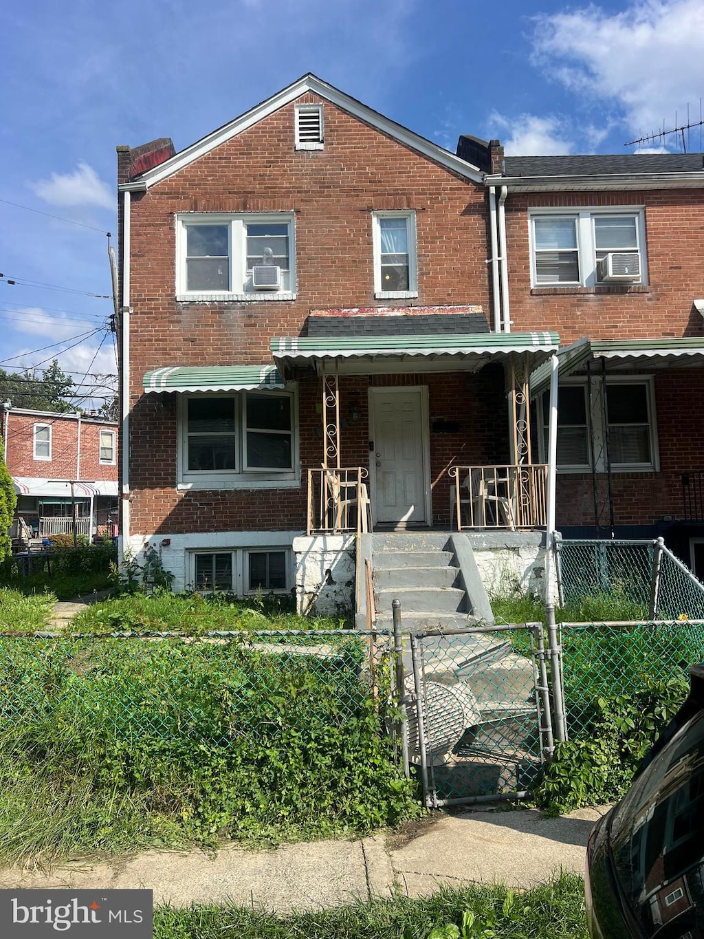 239 N Culver St, Baltimore, MD 21229 - townhome / multi-family property featuring brick siding, a fenced front yard, and covered porch