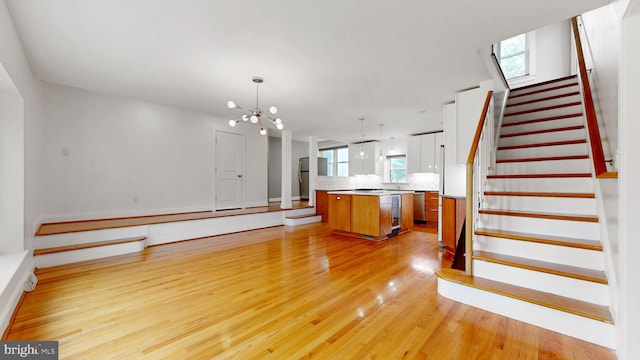 225 Dupont Cir, Wilmington, DE 19809 - kitchen with a center island, light wood-style floors, a chandelier, open floor plan, and brown cabinets