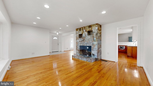 225 Dupont Cir, Wilmington, DE 19809 - unfurnished living room featuring light wood-type flooring, a large fireplace, and recessed lighting