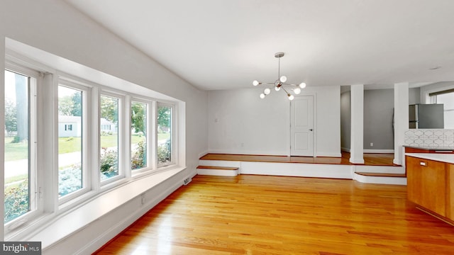 225 Dupont Cir, Wilmington, DE 19809 - unfurnished dining area with plenty of natural light, light wood finished floors, and a chandelier