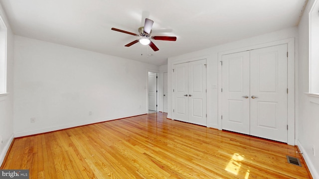 225 Dupont Cir, Wilmington, DE 19809 - unfurnished bedroom with multiple closets, light wood-style flooring, and a ceiling fan