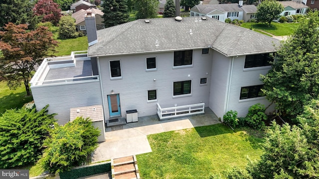 225 Dupont Cir, Wilmington, DE 19809 - rear view of property featuring a chimney, a patio, a lawn, and brick siding