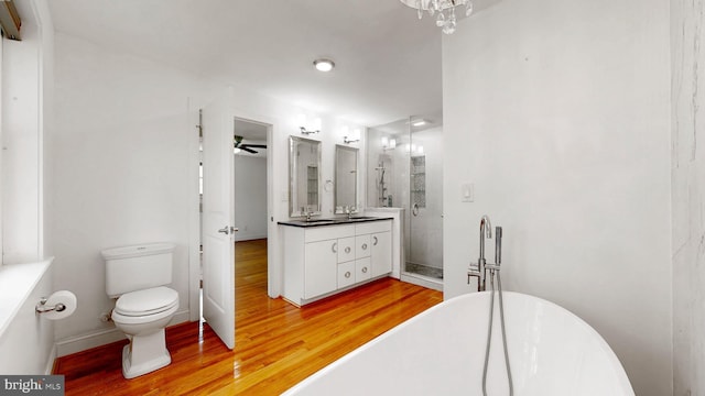 225 Dupont Cir, Wilmington, DE 19809 - full bathroom with vanity, wood finished floors, a shower stall, a freestanding tub, and a ceiling fan