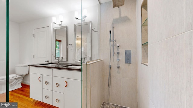 225 Dupont Cir, Wilmington, DE 19809 - bathroom featuring a tile shower, double vanity, and wood finished floors