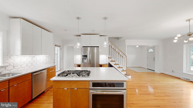 225 Dupont Cir, Wilmington, DE 19809 - kitchen with stainless steel appliances, light wood-type flooring, decorative backsplash, and healthy amount of natural light