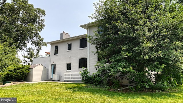 225 Dupont Cir, Wilmington, DE 19809 - back of house with a chimney, a yard, and a shed
