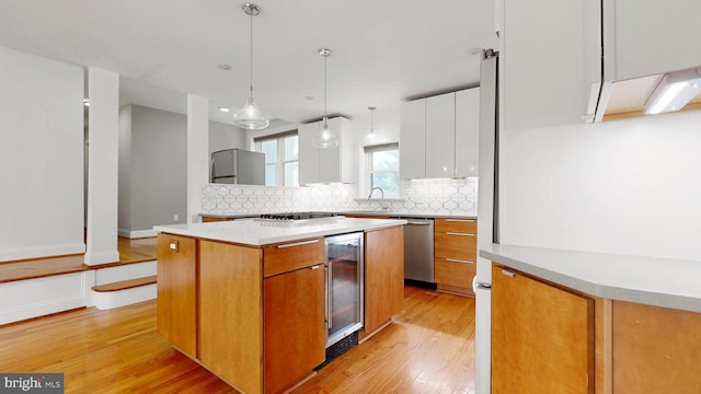 225 Dupont Cir, Wilmington, DE 19809 - kitchen featuring beverage cooler, light wood finished floors, dishwasher, decorative backsplash, and a center island