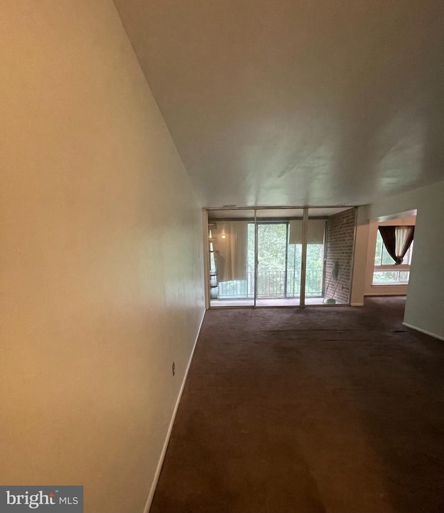 8477 Greenbelt Rd Unit 202, Greenbelt, MD 20770 - unfurnished living room featuring baseboards and dark colored carpet