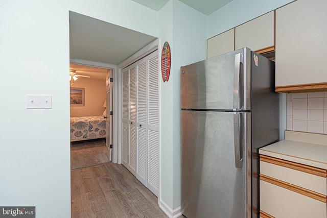 104 120th St Unit D82, Ocean City, MD 21842 - kitchen with freestanding refrigerator, wood finished floors, light countertops, a ceiling fan, and decorative backsplash