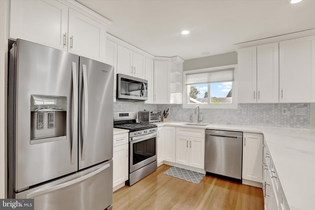869 Primrose Dr, Warminster, PA 18974 - kitchen with appliances with stainless steel finishes, a sink, light wood finished floors, white cabinetry, and tasteful backsplash