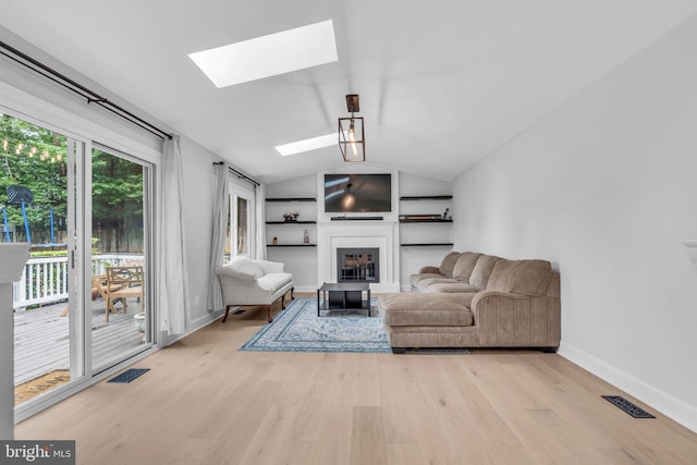 1606 Montmorency Dr, Vienna, VA 22182 - living area featuring a skylight, a glass covered fireplace, light wood-style flooring, vaulted ceiling, and baseboards