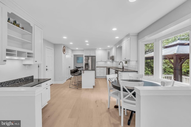 1606 Montmorency Dr, Vienna, VA 22182 - kitchen featuring stainless steel fridge with ice dispenser, a sink, white cabinets, tasteful backsplash, and light wood finished floors