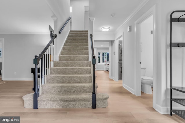 1606 Montmorency Dr, Vienna, VA 22182 - stairway with stacked washer and clothes dryer, wood finished floors, crown molding, and baseboards