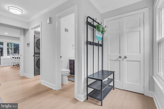 1606 Montmorency Dr, Vienna, VA 22182 - hallway featuring stacked washing machine and dryer, light wood-style flooring, crown molding, and baseboards