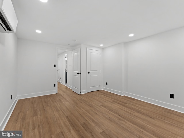 2331 N Front St, Philadelphia, PA 19133 - basement with baseboards, wood finished floors, recessed lighting, and a wall unit AC