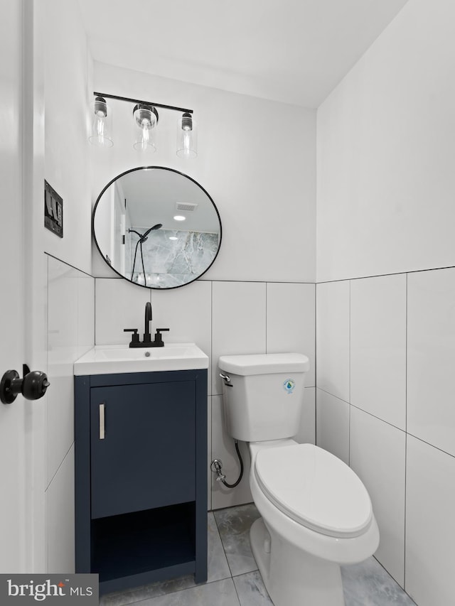 2331 N Front St, Philadelphia, PA 19133 - bathroom featuring vanity, marble finish floors, toilet, and tile walls