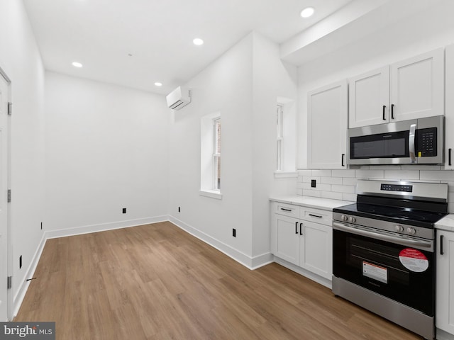 2331 N Front St, Philadelphia, PA 19133 - kitchen featuring stainless steel appliances, light wood-type flooring, baseboards, recessed lighting, and tasteful backsplash