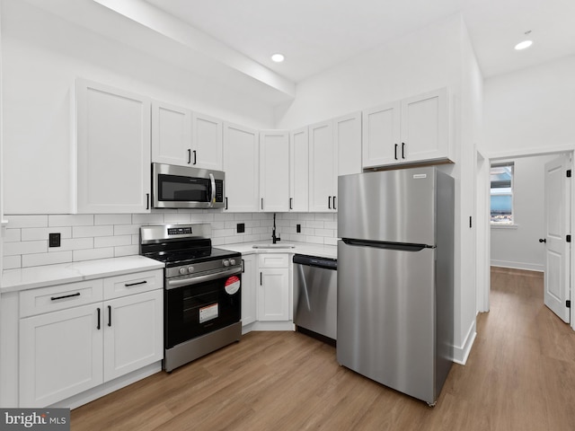 2331 N Front St, Philadelphia, PA 19133 - kitchen featuring appliances with stainless steel finishes, a sink, light countertops, light wood-type flooring, and recessed lighting