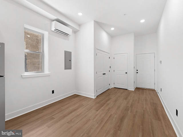 2331 N Front St, Philadelphia, PA 19133 - empty room with electric panel, a wall mounted air conditioner, light wood finished floors, baseboards, and recessed lighting