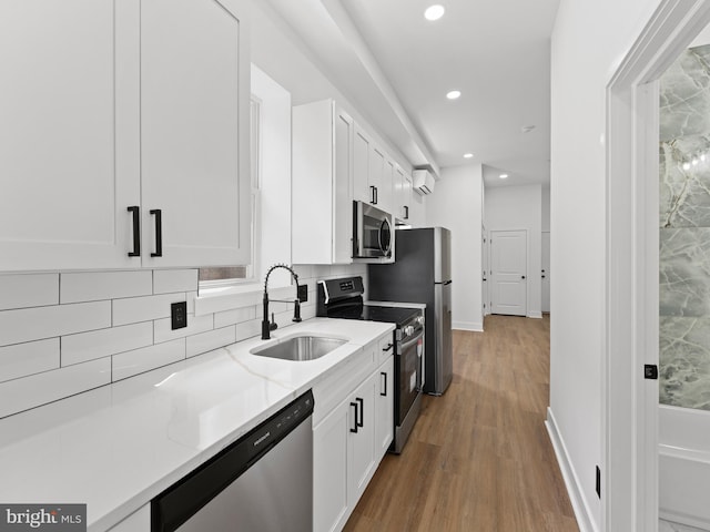 2331 N Front St, Philadelphia, PA 19133 - kitchen featuring appliances with stainless steel finishes, a sink, light wood-type flooring, white cabinets, and recessed lighting