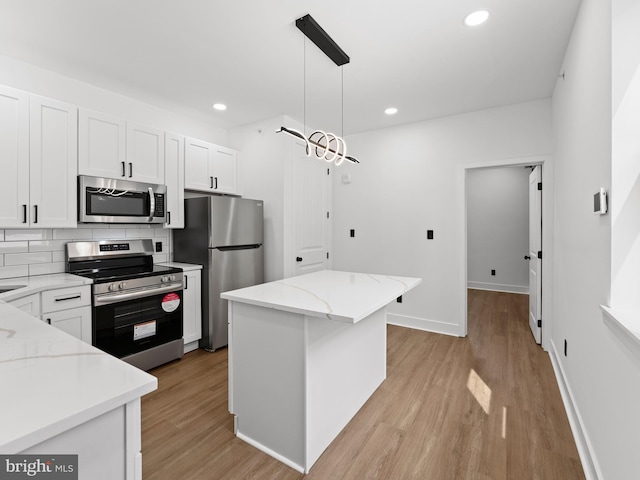 2331 N Front St, Philadelphia, PA 19133 - kitchen featuring appliances with stainless steel finishes, light wood-type flooring, white cabinets, recessed lighting, and pendant lighting