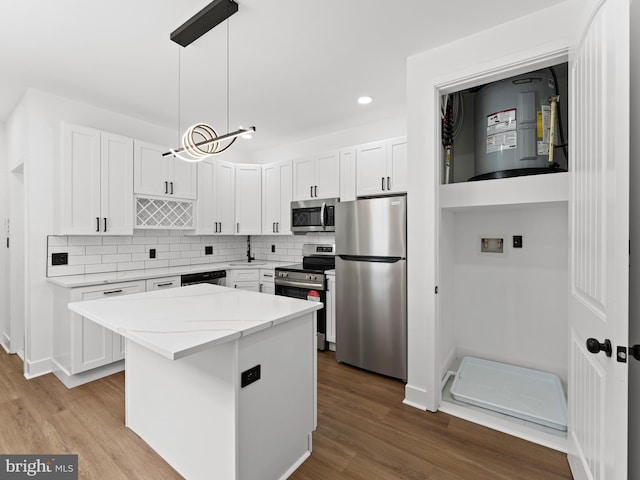 2331 N Front St, Philadelphia, PA 19133 - kitchen with appliances with stainless steel finishes, white cabinetry, a kitchen island, a sink, and wood finished floors