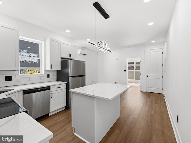 2331 N Front St, Philadelphia, PA 19133 - kitchen with appliances with stainless steel finishes, backsplash, wood finished floors, white cabinetry, and a center island