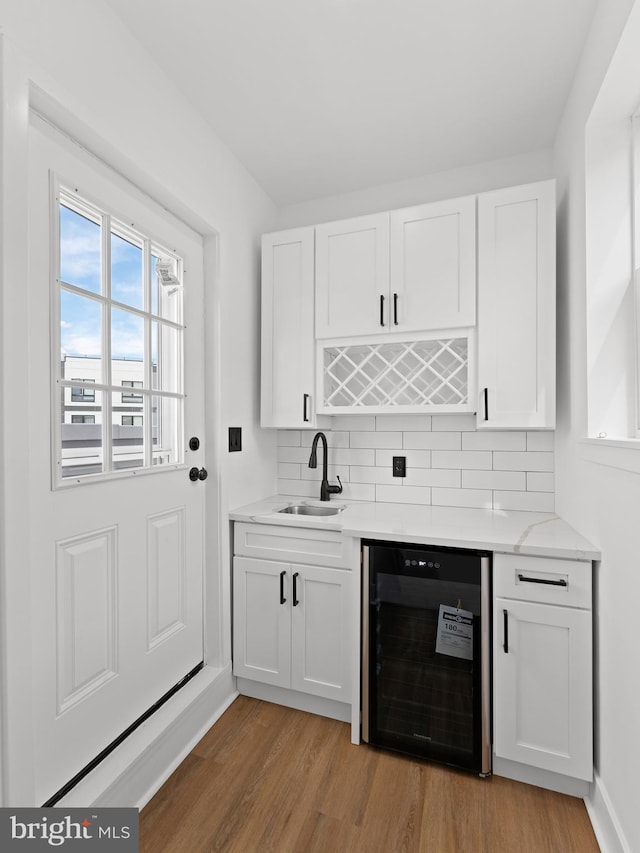 2331 N Front St, Philadelphia, PA 19133 - kitchen with beverage cooler, a sink, light wood finished floors, tasteful backsplash, and white cabinetry