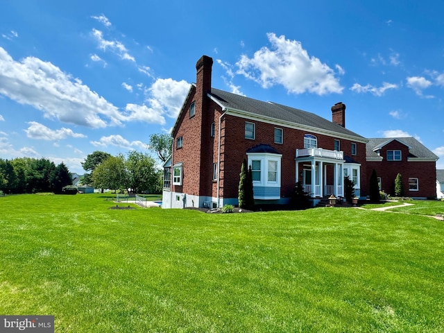 324 W Orchard Dr, Palmyra, PA 17078 - view of front facade with a chimney, a front yard, brick siding, and a balcony