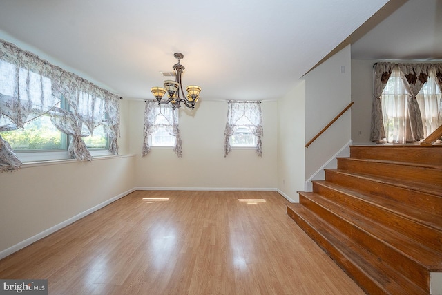 405 Garden Ln, Aston, PA 19014 - unfurnished dining area with a chandelier, light wood-style flooring, stairway, and baseboards