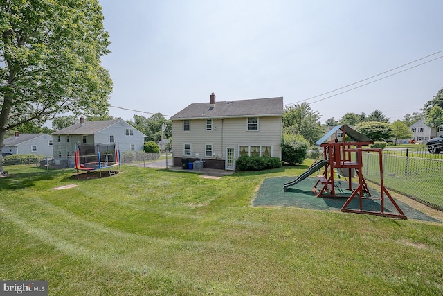 405 Garden Ln, Aston, PA 19014 - rear view of property with a trampoline, a playground, and a chimney
