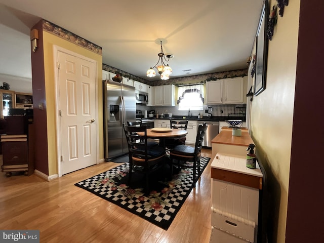 7324 Summerwind Cir, Laurel, MD 20707 - dining space with light wood-style floors, a chandelier, and baseboards