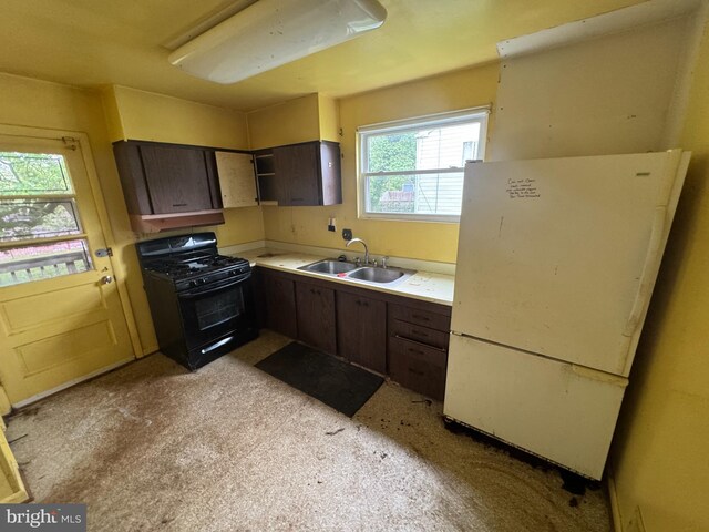 8541 Lucerne Rd, Randallstown, MD 21133 - kitchen featuring black gas range oven, a sink, freestanding refrigerator, light countertops, and dark brown cabinets