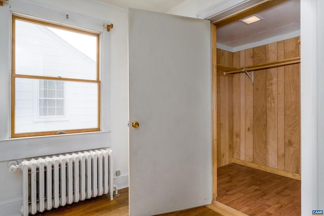 1316 Chesapeake St, Charlottesville, VA 22902 - bedroom featuring radiator heating unit, wood finished floors, a closet, and wooden walls