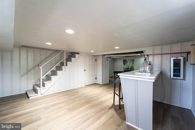 3232 N Rolling Rd, Baltimore, MD 21244 - kitchen with wood finished floors, a kitchen bar, light countertops, a peninsula, and recessed lighting