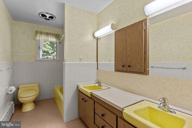 645 Lily Rd, Warminster, PA 18974 - full bathroom featuring baseboard heating, toilet, double vanity, a wainscoted wall, and tile walls
